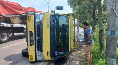 Dihantam Bus, Truk Bermuatan Biji Plastik Terguling di Jalan Nasional Lamongan