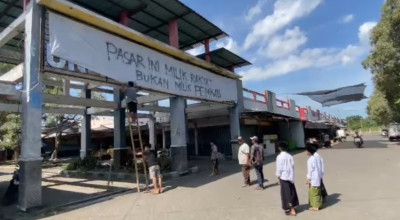 Pedagang Pasar Baru Kencong Tutup Logo Pemkab Jember dengan Kain Kafan