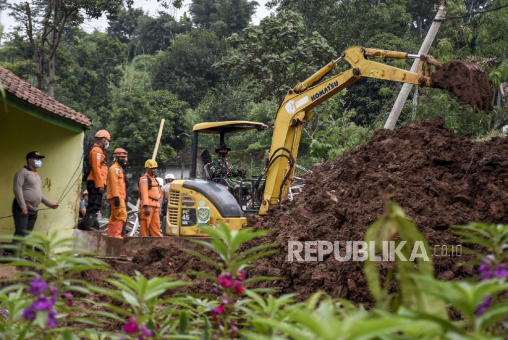 Petugas membersihkan material longsor yang menimbun rumah warga di Desa Cihanjuang, Kecamatan Cimanggung, Kabupaten Sumedang (Foto: Abdan Syakura/Republika)