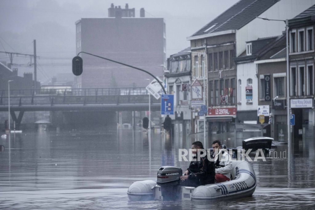 Warga menggunakan rakit karet di tengah banjir setelah Sungai Meuse jebol saat banjir besar di Liege, Belgia, Kamis, 15 Juli 2021 (Foto: AP/Valentin Bianchi via Republika)