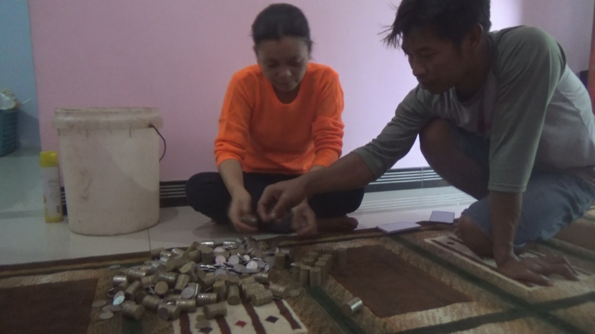 Maisyaroh (33) dan Slamet Amin (35) menghitung uang koin yang akan digunakan untuk membeli motor.