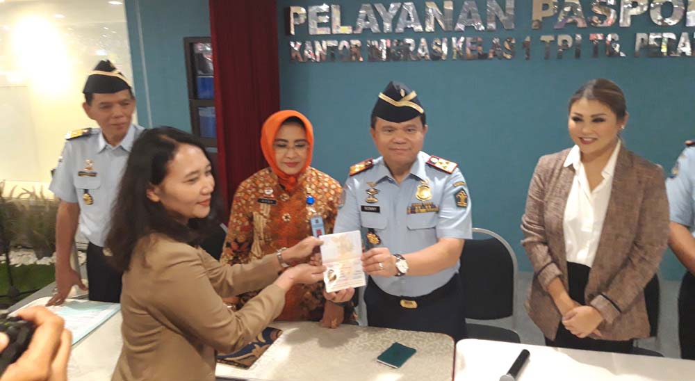 Dirjen Imigrasi Ronny F Sompie memberikan paspor pertama yang dicetak ke pemiliknya