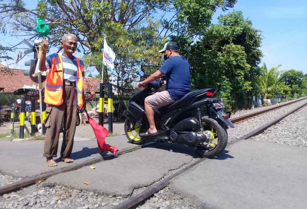 Tak Digaji, Kakek ini Jaga Perlintasan KA Tanpa Palang di Kota Probolinggo