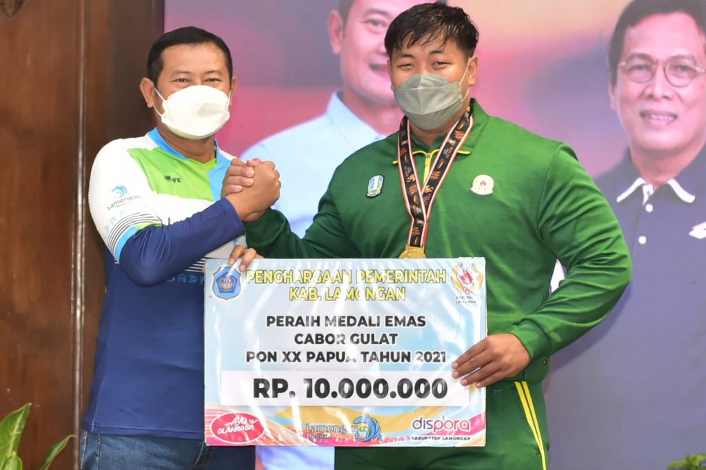 Bupati Lamongan Yuhronur Efendi menyerahkan bonus kepada masing-masing peraih medali PON XX Papua. (Foto: Istimewa)
