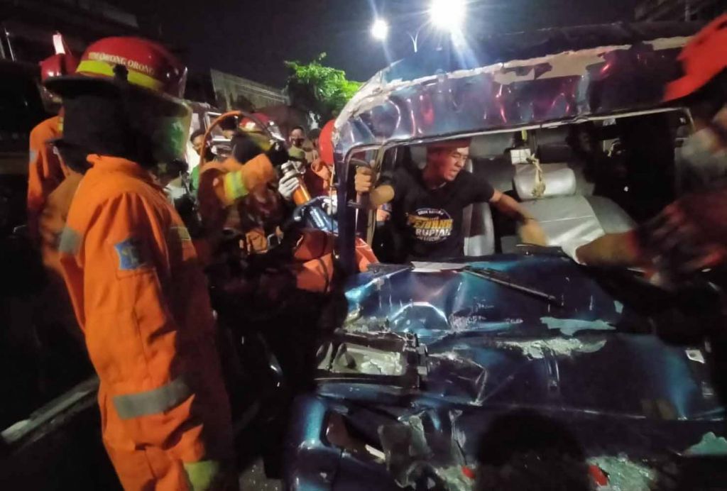 Petugas evakuasi korban yang terjepit mobil