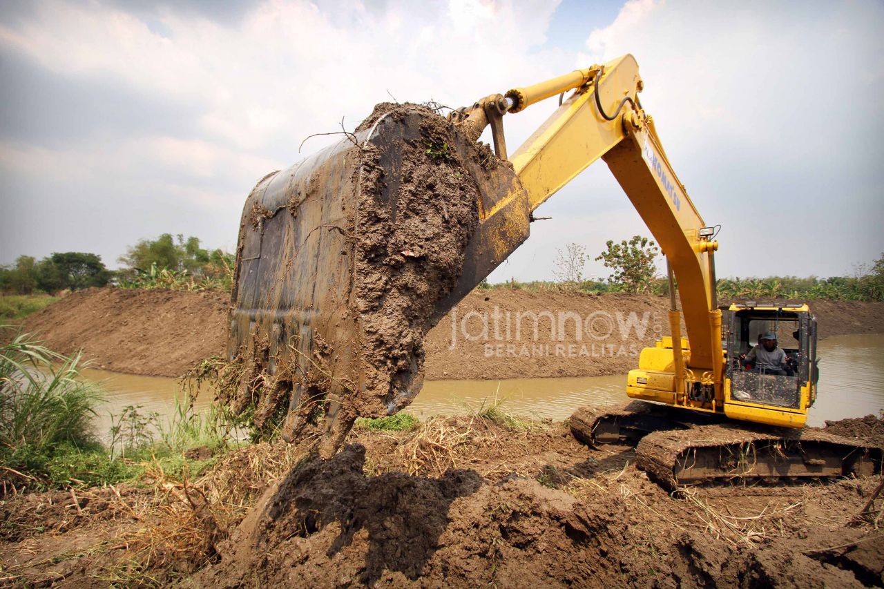 Sebuah excavator saat proses normalisasi Kali Lamong. (Foto: Sahlul Fahmi/jatimnow.com)