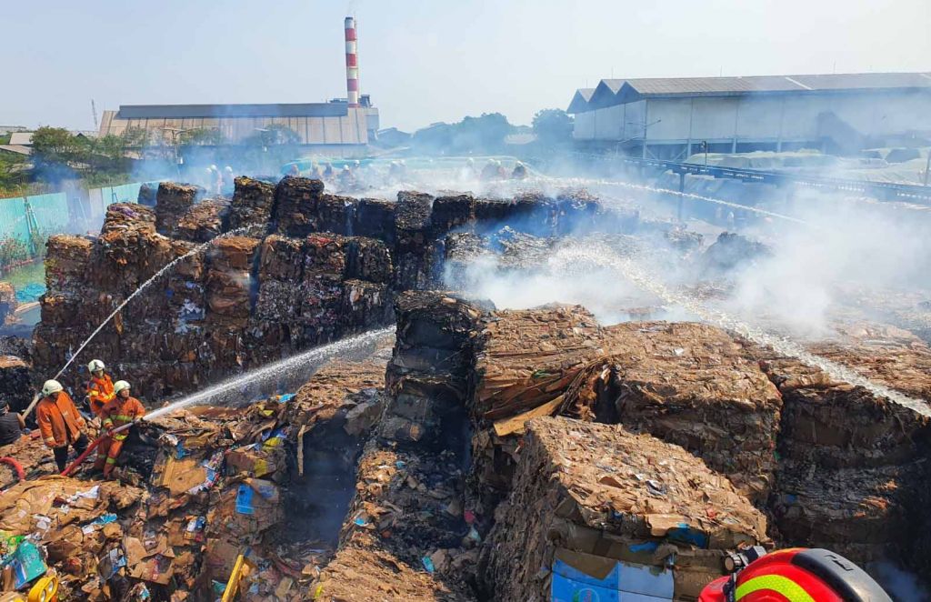 Petugas PMK berupaya padamkan api yang membakar tumpukan kertas bekas (foto: istimewa)