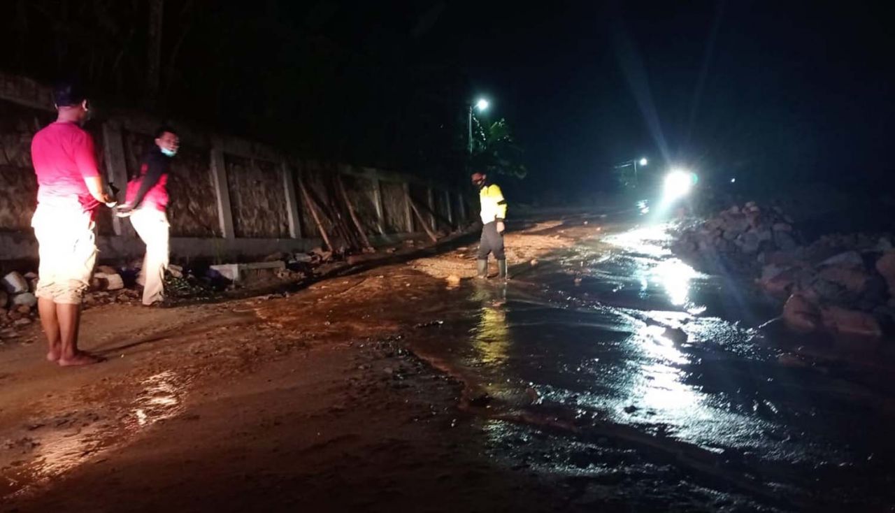 Material batu dan lumpur yang terbawa banjir menutup jalan penghubung dua desa di Pacitan