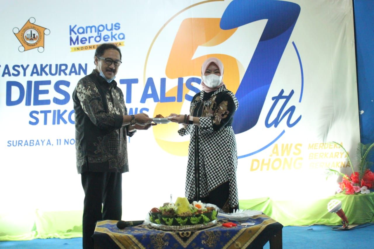 Ketua Yayasan, Imawan Mashuri dan Ketua Stikosa-AWS Meithiana ketika prosesi pemotongan tumpeng dalam tasyakuran Dies Natalis ke-57