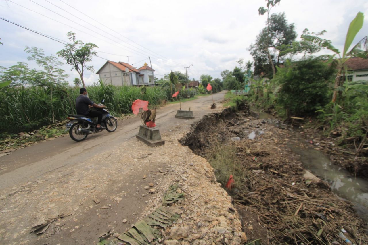Warga memasang kijing dan nisan di jalanan rusak di Ponorogo. (Foto: Istimewa)