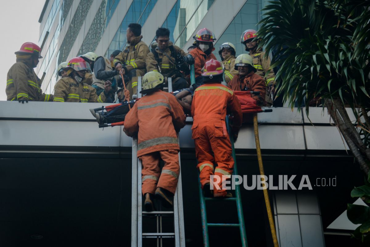 Petugas Suku Dinas Penanggulangan Kebakaran dan Penyelamatan (Gulkarmat) saat melakukan proses evakuasi kebakaran Gedung Cyber, Jakarta (Foto: Republika/Thoudy Badai)