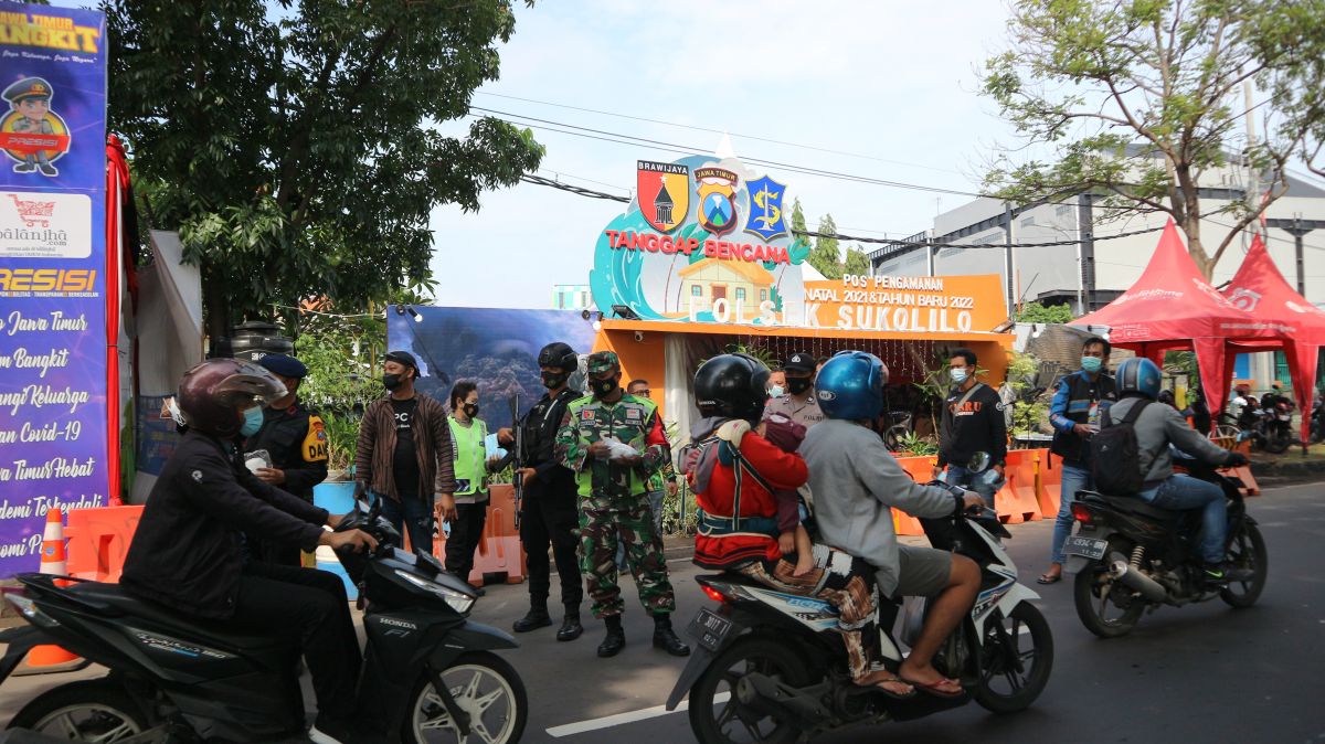 Polsek Sukolilo bagi masker untuk pengguna jalan di Ir Soekarno. (Foto: Fajar Mujianto/jatimnow.com)