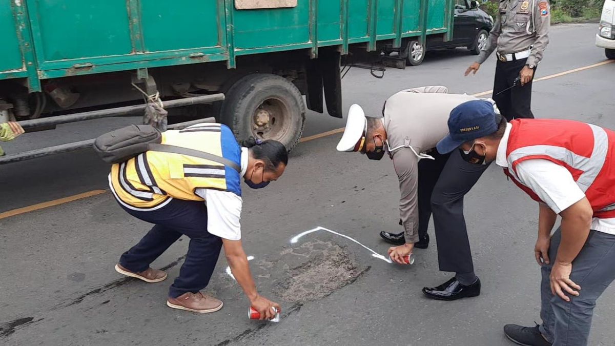 Kasat Lantas Polres Mojokerto AKP Arpan saat memberi tanda jalan berlubang (Foto: Achmad Supriyadi/jatimnow.com)
