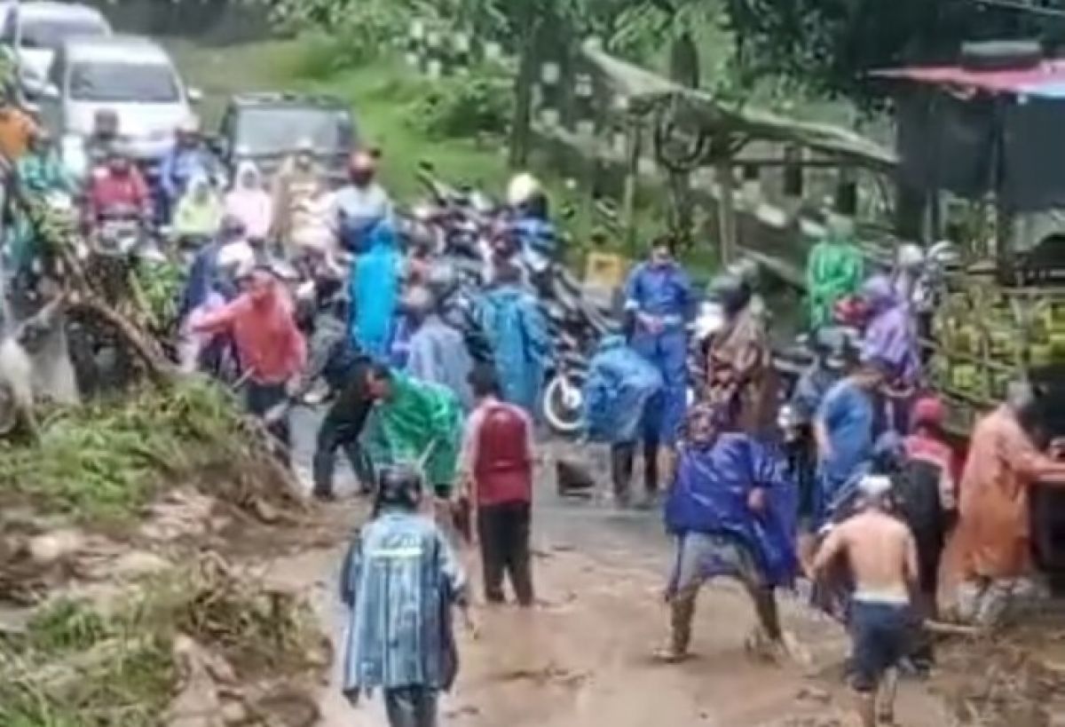 Warga bergotong royong membersihkan material longsor di Kabupaten Pasuruan. (Foto: Tangkapan Layar/jatimnow.com)