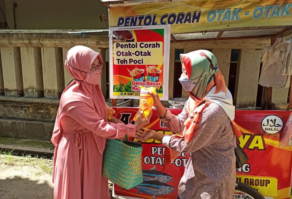 Aksi Rima Darma membagikan minyak goreng secara gratis. (Foto: Mita Kusuma/jatimnow.com)