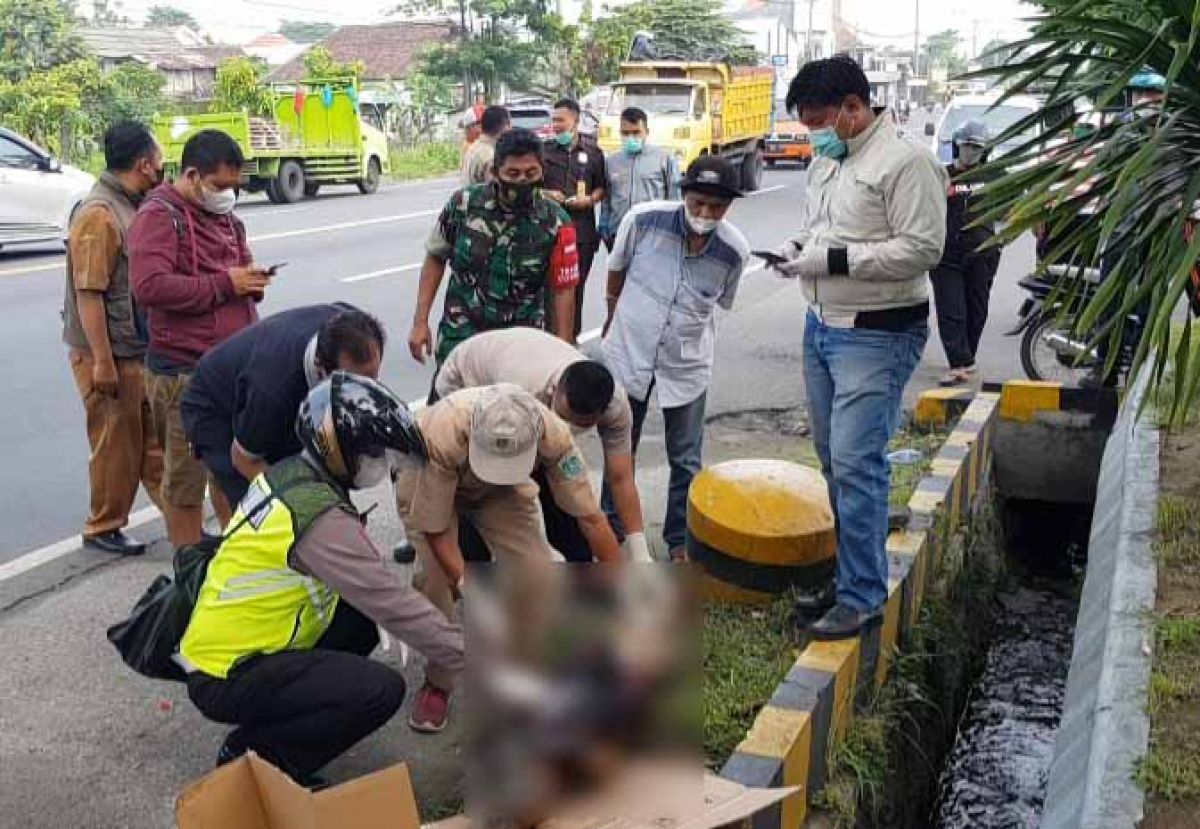 Mayat tanpa identitas tergeletak di pingir jalan depan perusahaan di Desa Kepulungan, Kecamatan Gempol, Kabupaten Pasuruan.  (Foto: Moch. Rois/jatimnow.com)