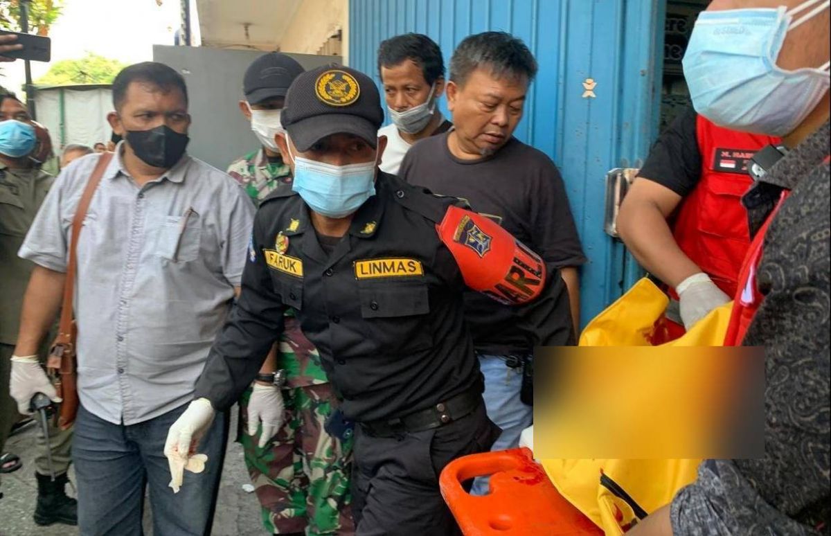 Petugas mengevakuasi korban perampokan disertai pembunuhan di Tandes. (Foto: Info Kedaruratan 112/jatimnow.com)