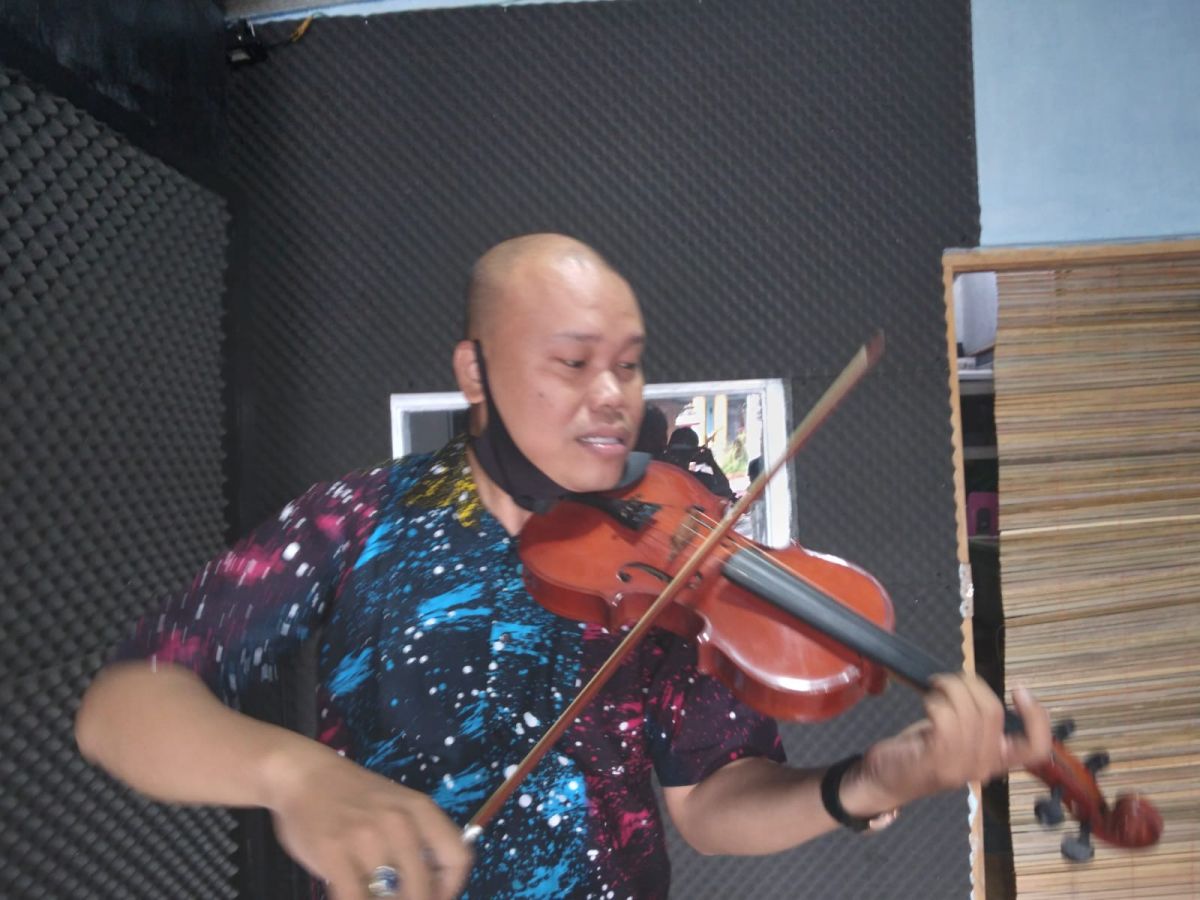 Pak Ipin, dirigen yang viral saat bermain biola (Foto: Mita Kusuma/jatimnow.com)