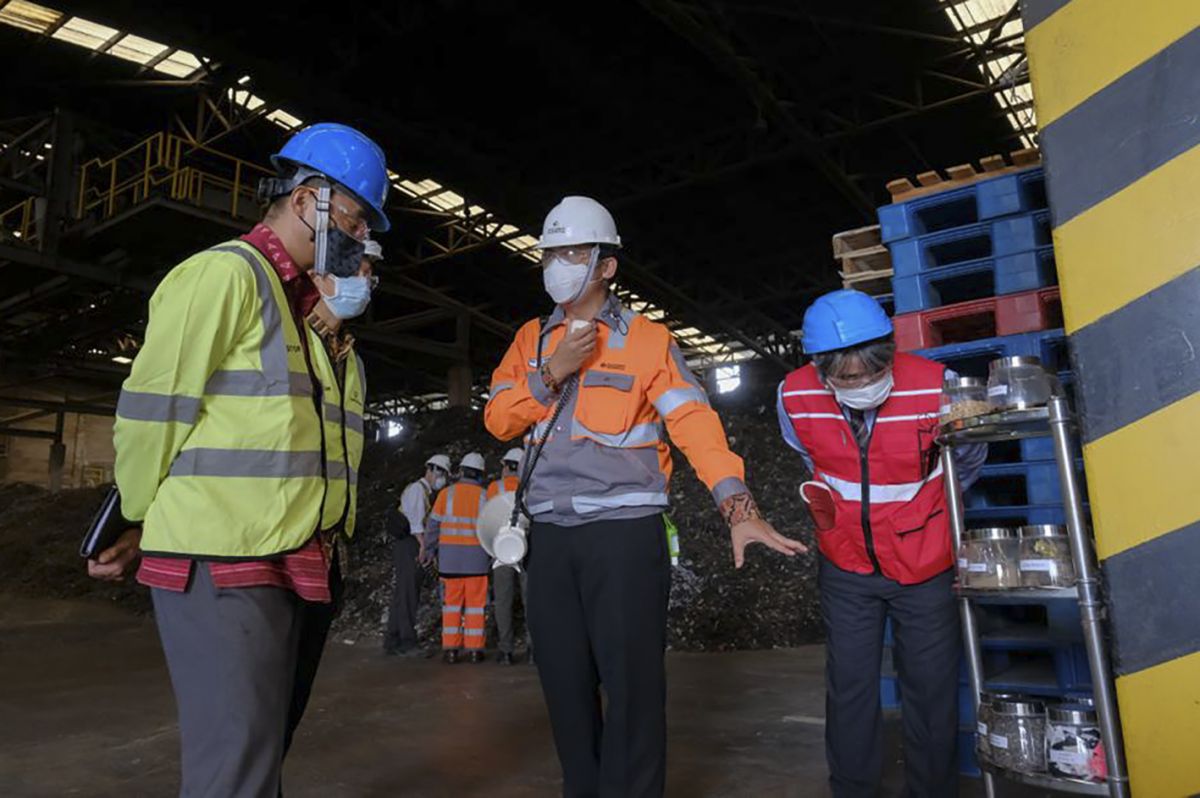 Minister for Economic Affairs and Development dari Kedutaan Besar Jepang di Indonesia, Masato Usui (jaket hijau), mendengarkan penjelasan proses pengolahan sampah menjadi bahan bakar alternatif di GreenZone, fasilitas pengolahan limbah industri dan sampah