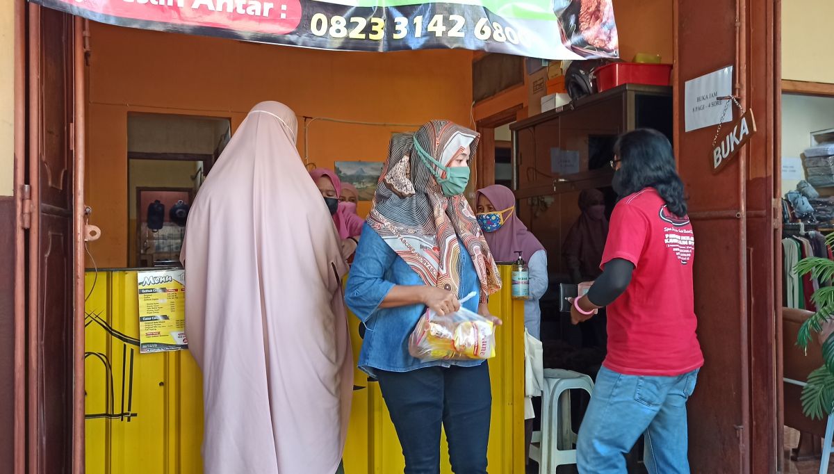 Pembeli minyak goreng di rumah Maya Nika Sari, berdatangan dengan membawa kupon. (Foto-foto: Mita Kusuma/jatimnow.com)