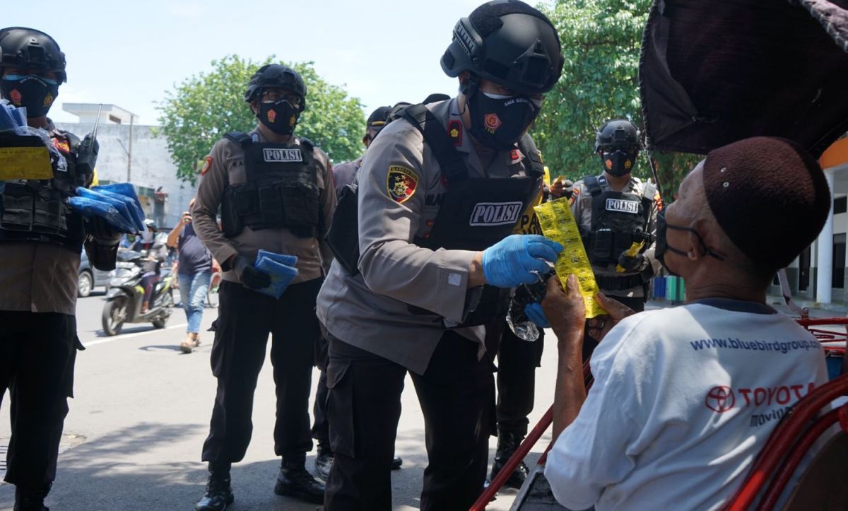 Pamor Keris Kecamatan Tambaksari membagikan vitamin dan jas hujan bagi abang becak. (Foto: Farizal Tito/jatimnow.com)