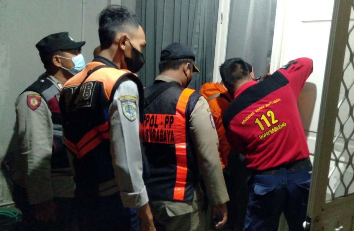 Petugas gabungan mencoba membuka pintu rumah untuk menyelamatkan korban