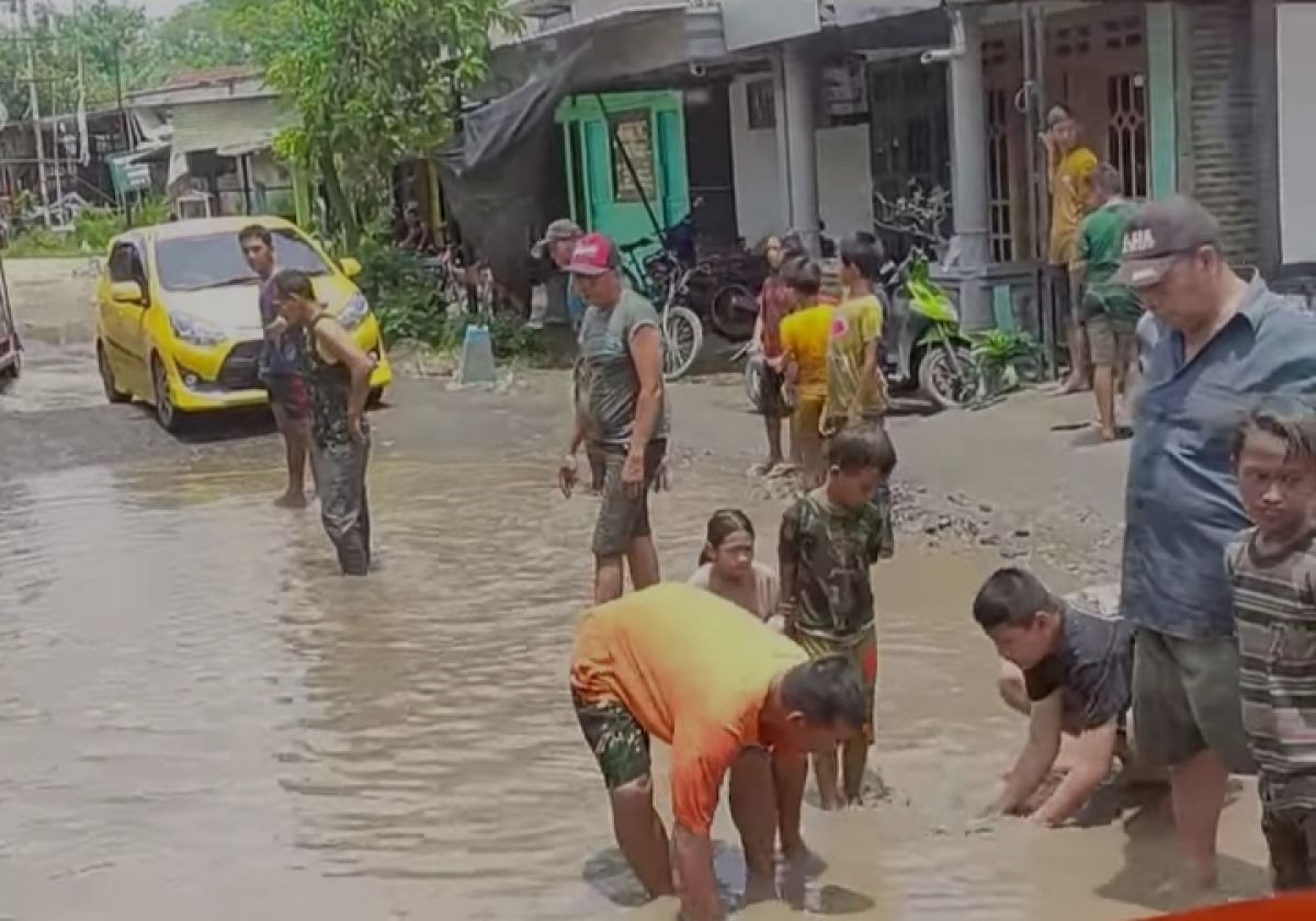 Tangkapan layar video warga menangkap ikan lele di kubangan jalan rusak.