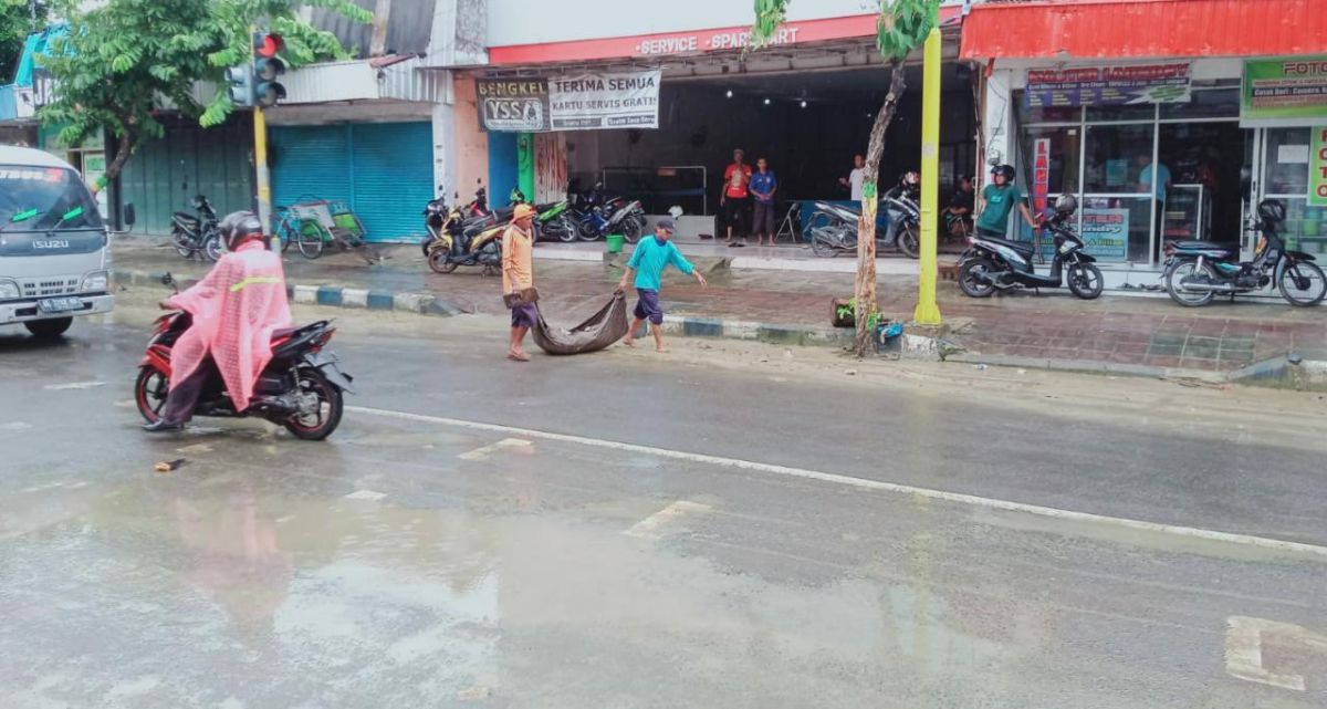 Warga Pamekasan membersihkan sisa-sisa lumpur bekas banjir.(Foto: BPBD Pamekasan)