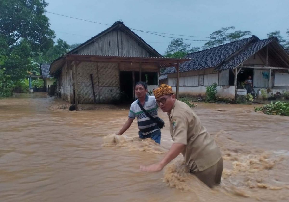 Kepala Desa Kandangan, Riyono saat membantu mengevakuasi warga yang rumahnya terendam banjir (Foto: Kepala Desa Kandangan for jatimnow.com)