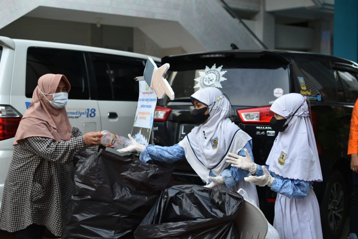 Para siswa SD Muhammadiyah 18 Surabaya saat melayani warga yang menukarkan botol plastik bekas dengan sembako (Foto-foto: Farizal Tito/jatimnow.com)