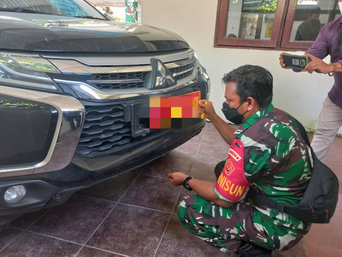 Petugas Subgab Garnisun 0812 Lamongan saat mengganti plat nomor pria yang digrebek pagi tadi. (Foto : Adyad Ammy/jatimnow.com)