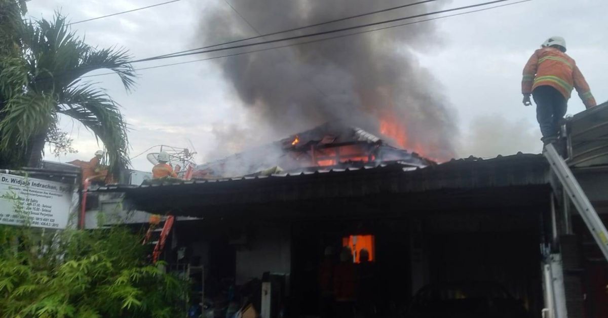 Petugas damkar berusaha memadamkan api yang melahap rumah sekaligus klinik di Kertajaya, Surabaya. (Foto: Dinas Pemadam Kebakaran Kota Surabaya/jatimnow.com)