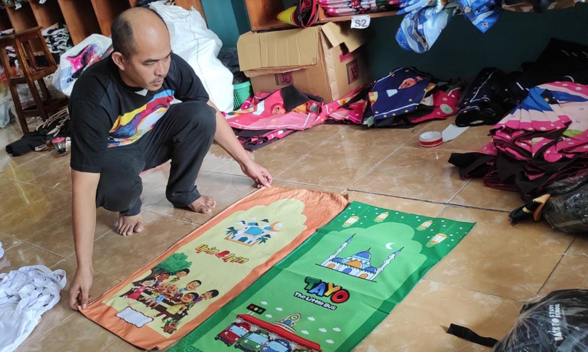 Sugiarto memperlihatkan produk sajadah karakter motif produksinya. (Foto-foto: Elok Aprianto/jatimnow.com)