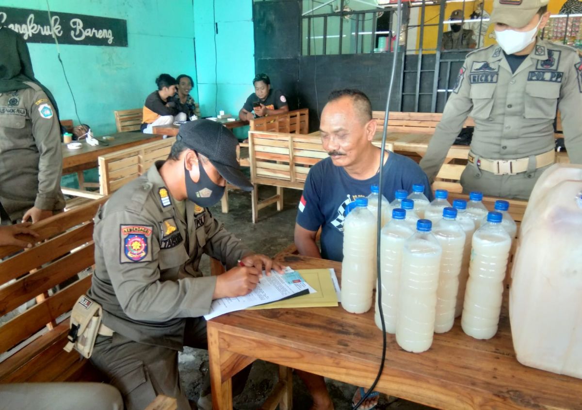 Petugas Satpol PP saat menyita puluhan miras berjenis towak di salah satu warung. (Foto: SatPol PP Lamongan for jatimnow.com)