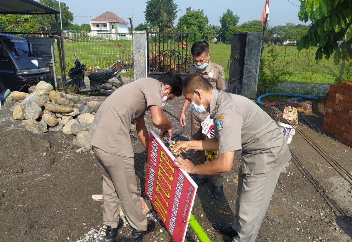 Aparat Penegak Perda saat menurunkan segel larangan pada bangunan tower di Jombang (Foto-foto: Elok Aprianto/jatimnow.com)