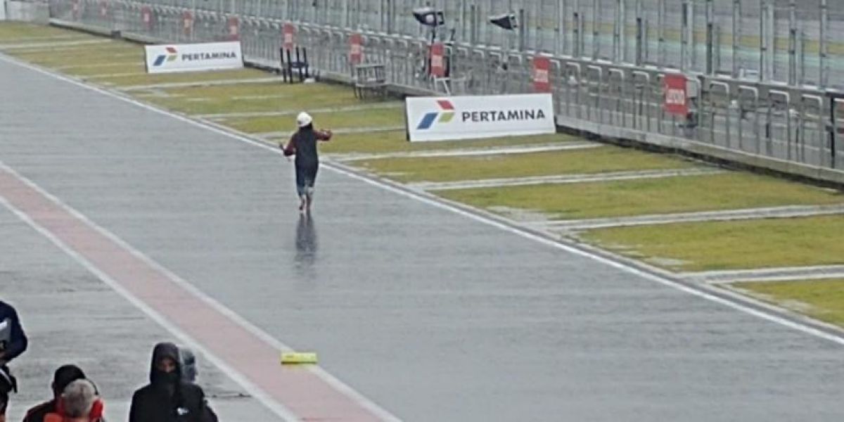 Seorang perempuan yang merupakan pawang hujan tampak berjalan di sekitar paddock sambil memukul bejana perunggu kecil yang dipegangnya (Foto: Republika/Mansyur Faqih)