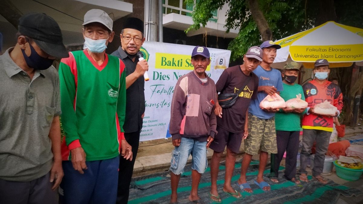 Rektor Unisla,Prof Bambang Eko Muljono saat memberikan bansos ke tukang becak di Jalan Ahmad Dahlan, Lamongan. (Foto : Adyad Ammy Iffansah/jatimnow.com)