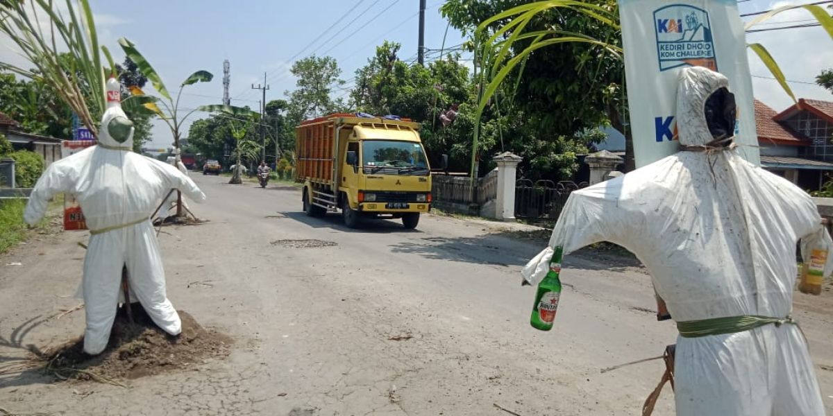 Kondisi jalan rusak di Desa Janti Wates, Kabupaten Kediri, yang dipasangi boneka tenaga kesehatan. (Foto : Yanuar Dedy/jatimnow.com)