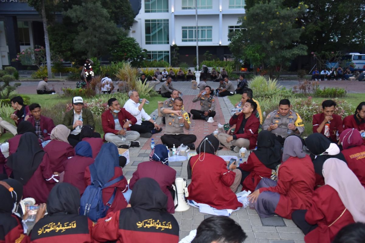 Mahasiswa IMM PC Lamongan buka bersama dengan polisi dan salat berjamaah seusai aksi demo di halaman Gedung Pemkab Lamongan. (Foto-foto: Adyad Ammy I./jatimnow.com)
