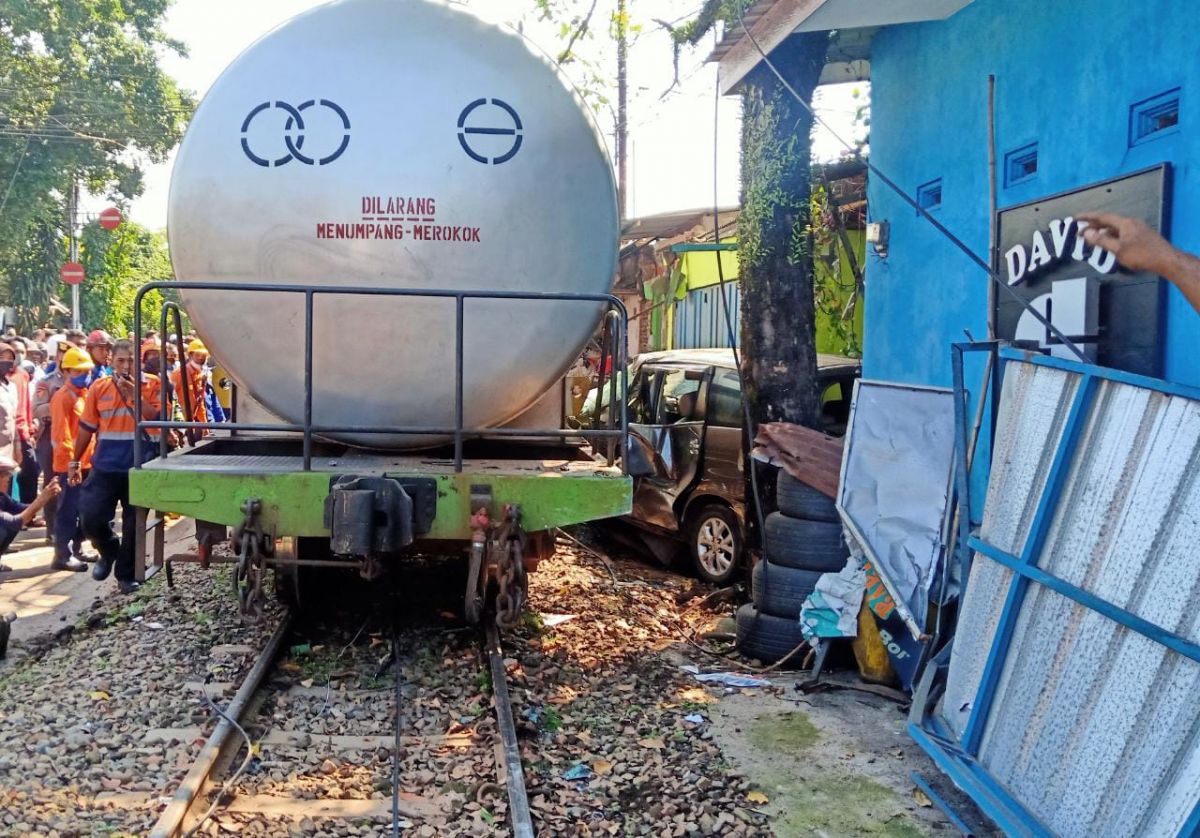KA membawa gerbong tangki menabrak mobil hingga terseret 10 meter di Kota Malang. (Foto: Galih Rakasiwi/jatimnow.com)