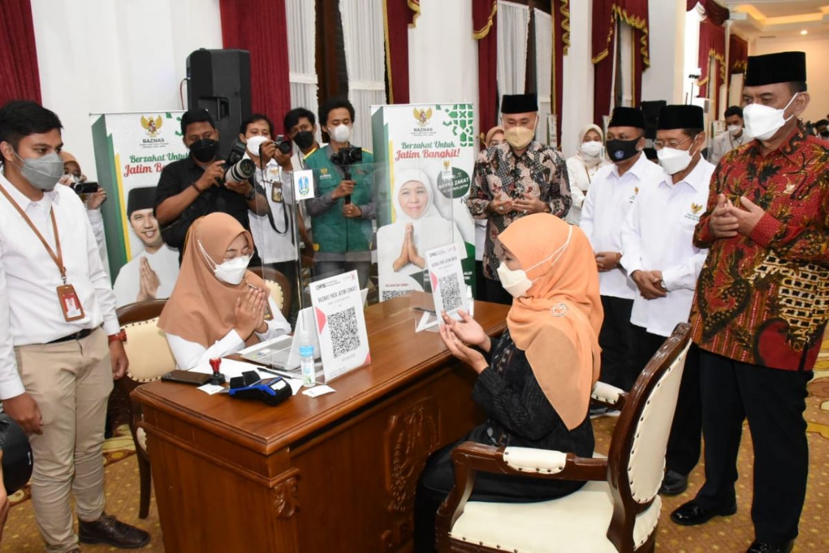 Gubernur Jawa Timur (Jatim) Khofifah Indar Parawansa menyerahkan zakat melalui Badan Amil Zakat Nasional (Baznas) di Gedung Negara Grahadi Surabaya.(Foto: Humas Pemprov Jatim)