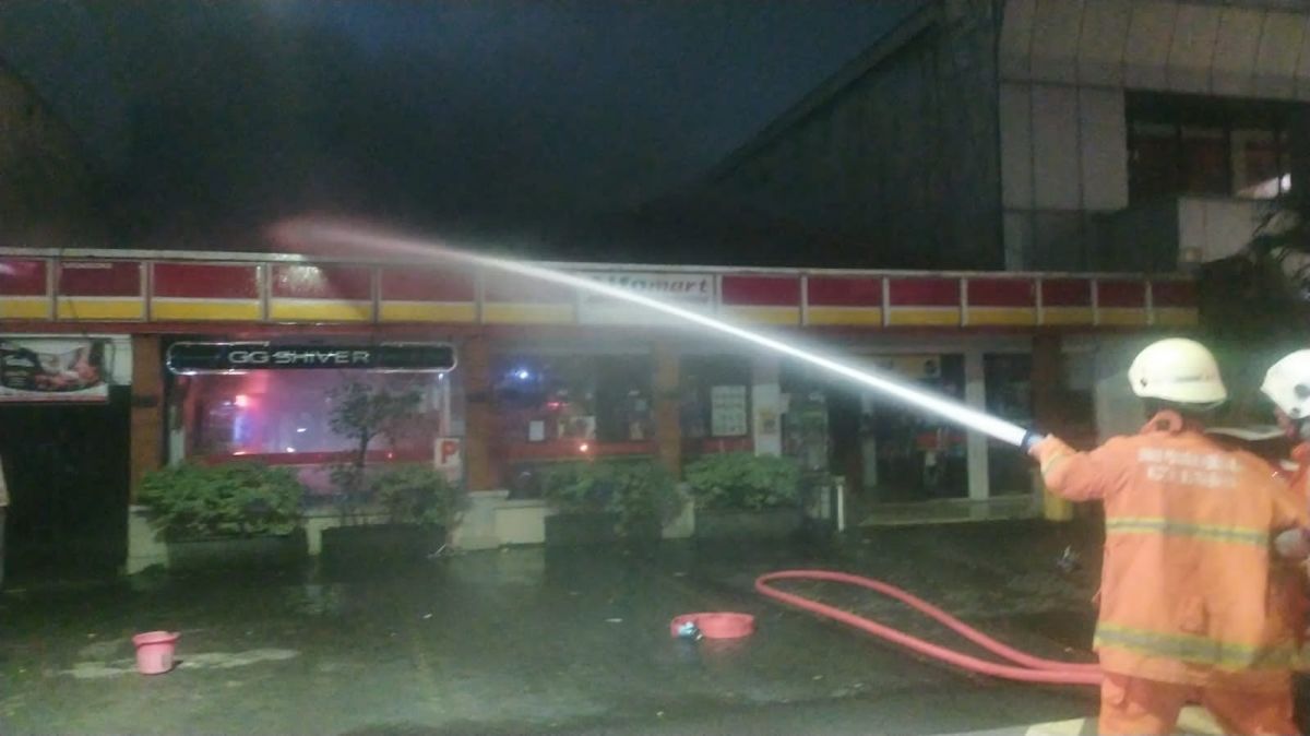 Petugas pemadam kebakaran saat berjibaku memadamkan api yang membakar minimarket. (Foto: Kedaruratan 112 Surabaya).