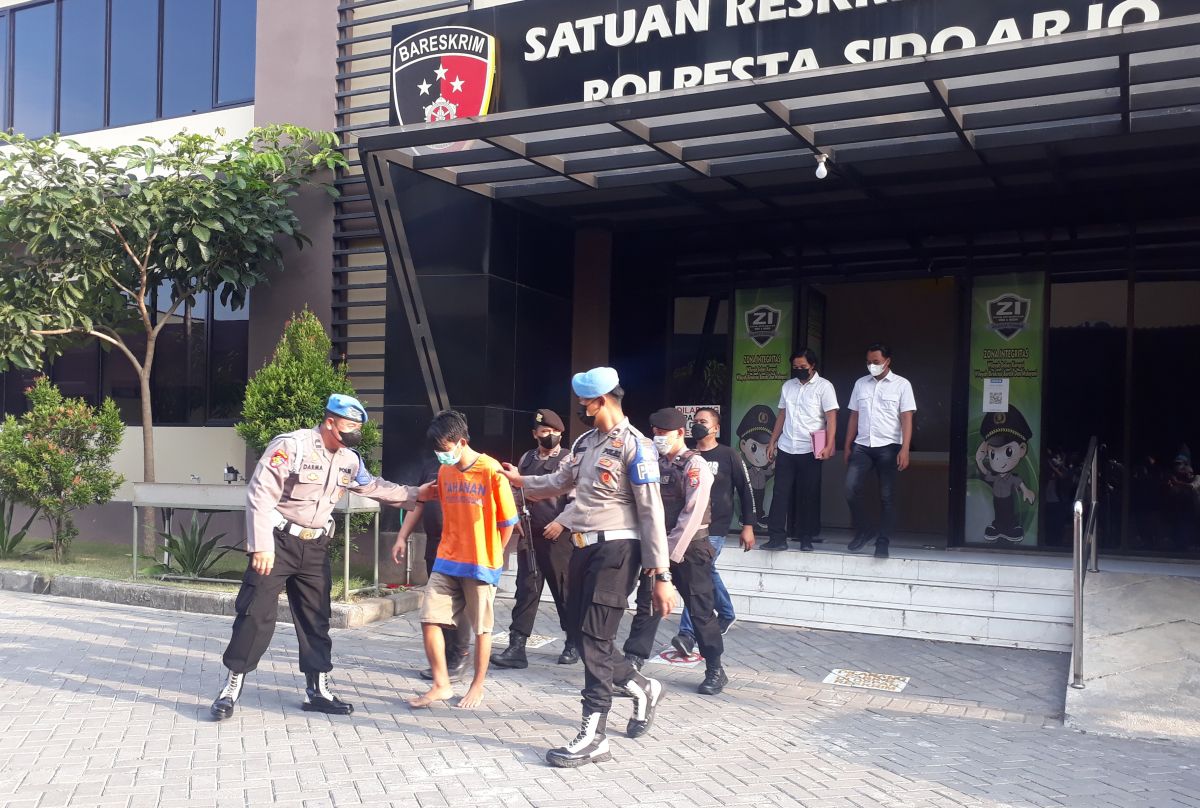 Tersangka RW saat digelandang di Mapolresta Sidoarjo. (Foto: Zainul Fajar/jatimnow.com)