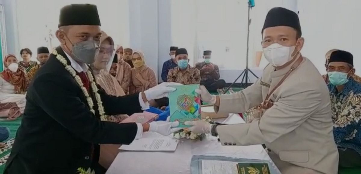 Salah satu pengantin melakukan wakaf Alquran (Foto: Ega for jatimnow.com)