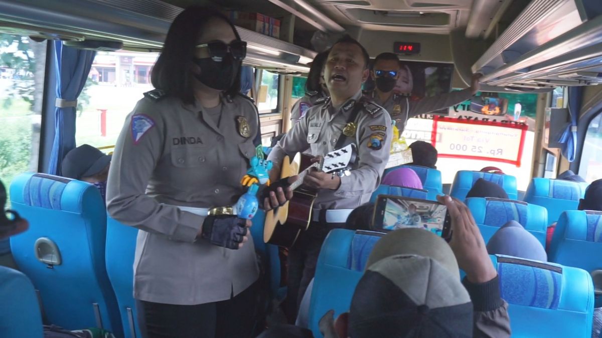 Sejumlah anggota polantas Polres Jombang saat menghibur para penumpang Bus Bagong, jurusan Surabaya ke Trenggalek.(Foto: Elok Aprianto)