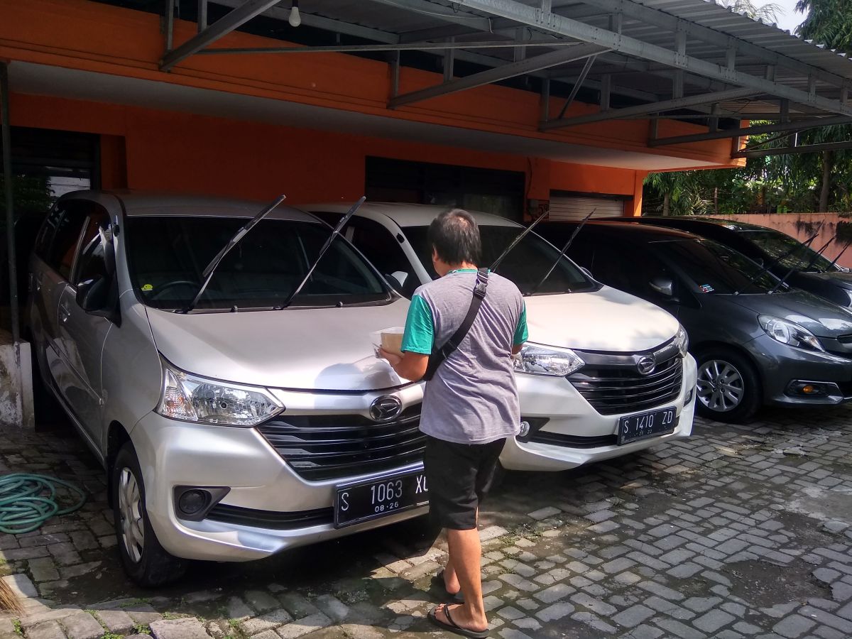 Pemilik rental mobil yang ada di jalan Patimura, Desa Sengon, Kecamatan Jombang, saat melakukan pengecekan kendaraan rental. (Foto: Elok Aprianto/jatimnow.com)