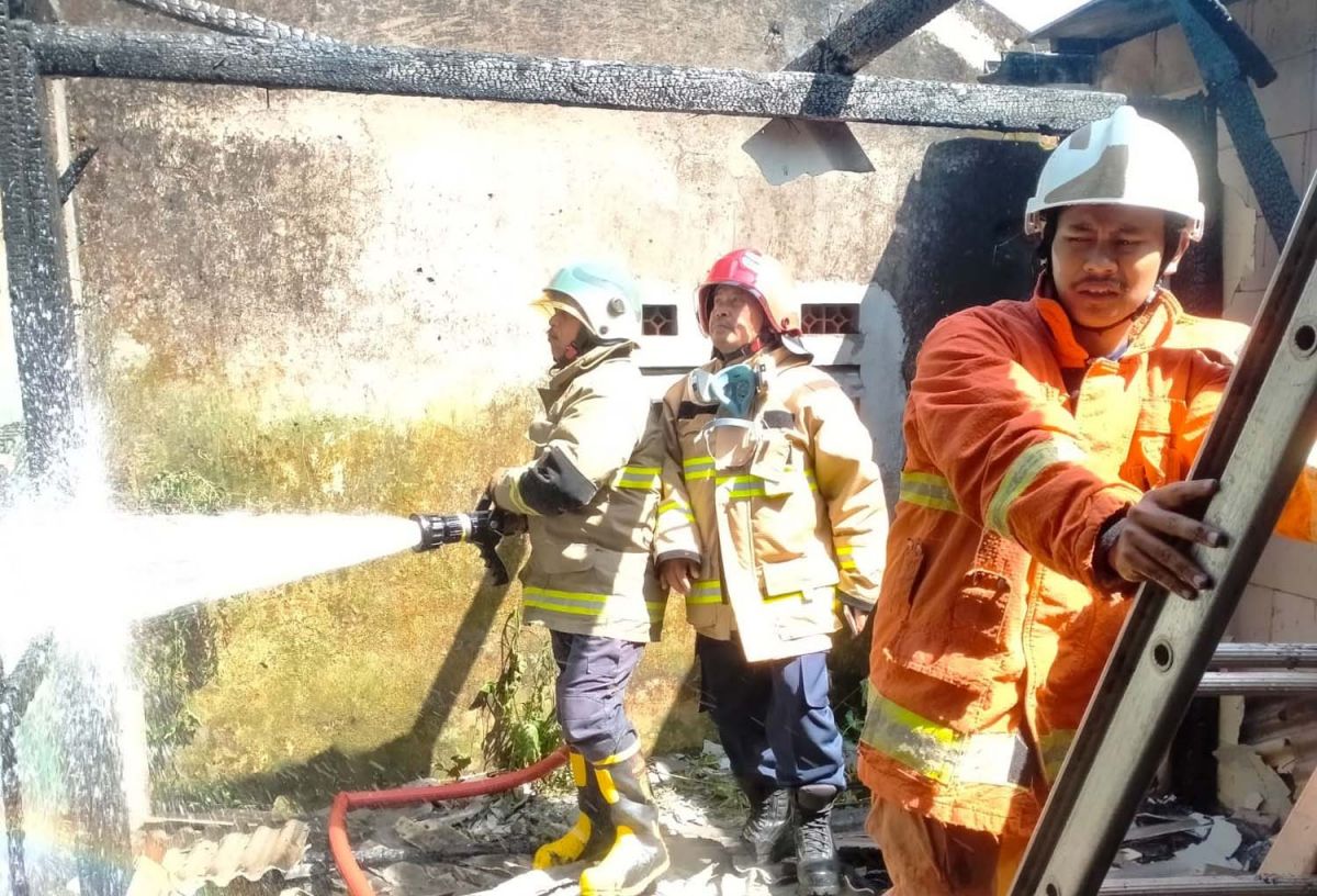 Petugas pemadam kebakaran sedang melakukan pembasahan di rumah yang terbakar (Foto: DPKP Kota Batu for jatimnow.com)