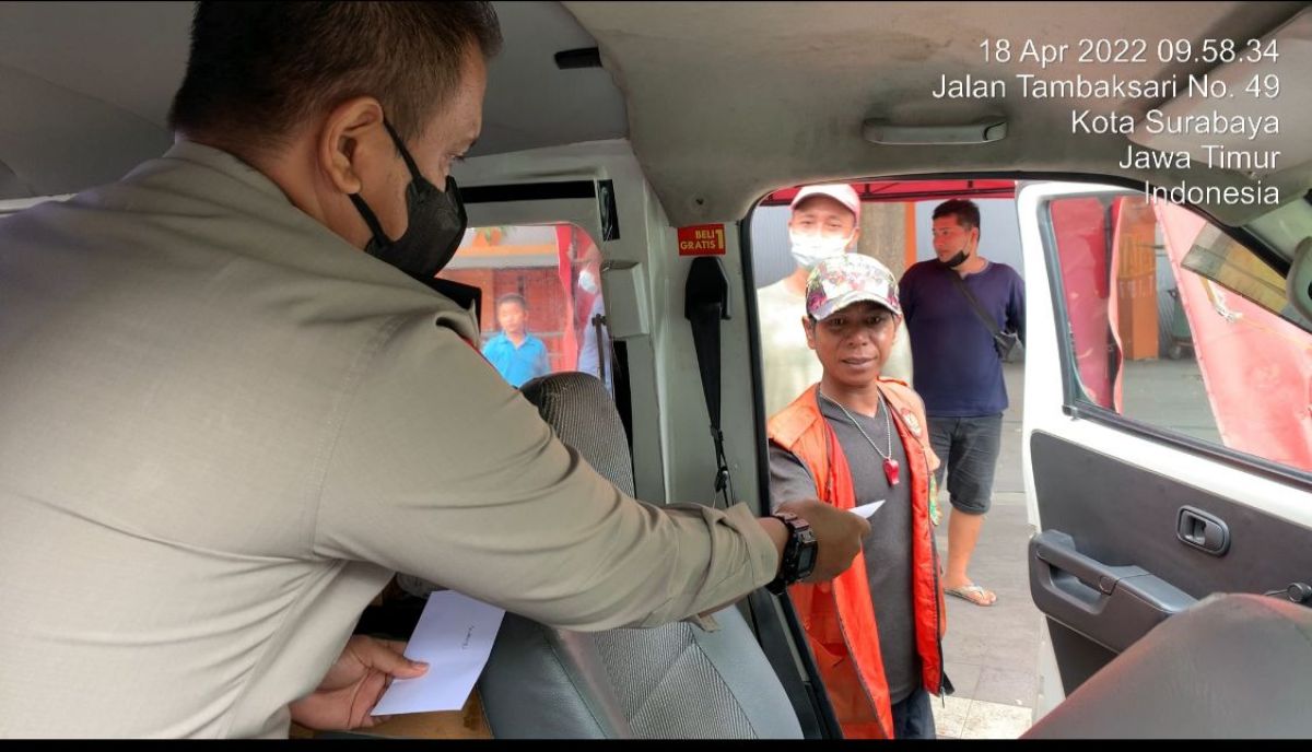 Petugas Samsat Keliling Manyar, berbagi pada pengayuh becak, tukang parkir dan warga di sekitar Stadion Gelora 10 Nopember. (Foto: Samsat Manyar/jatimnow.com)