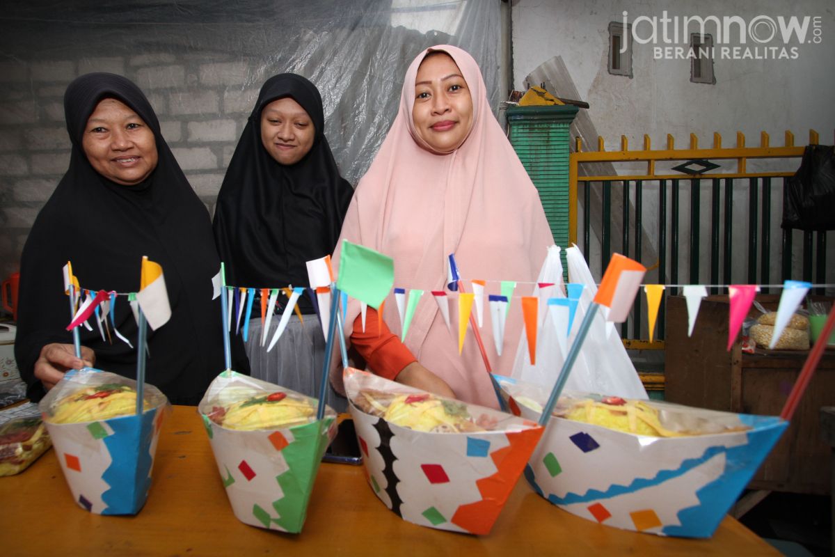 Mualifah (kiri) bersama anak dan cucunya di lapaknya.(Foto: Sahlul Fahmi/jatimnow.com)()