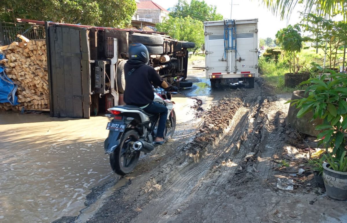 Truk bermuatan kayu terguling usai gagal melintasi jalan rusak di Sukodadi, Lamongan. (Foto: Gakkum Polres Lamongan for jatimnow.com)